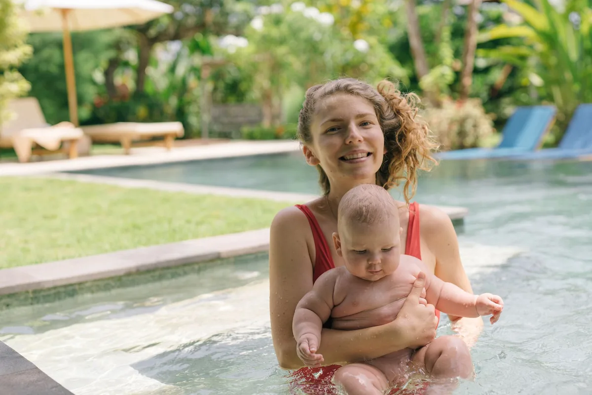 Un parent accompagne son bébé dans une piscine