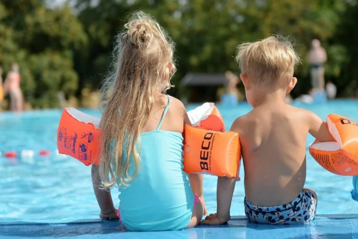 Enfants accompagnés avec différents équipements de baignade